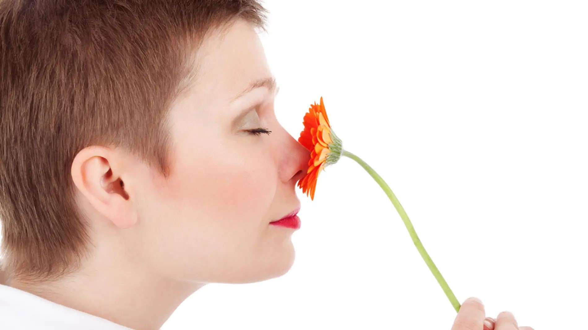 Mujer oliendo una flor